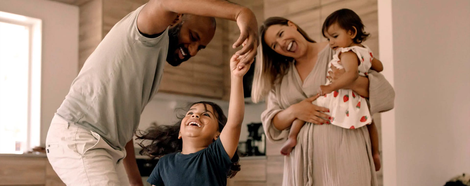 Foto på familj som dansar och skrattar