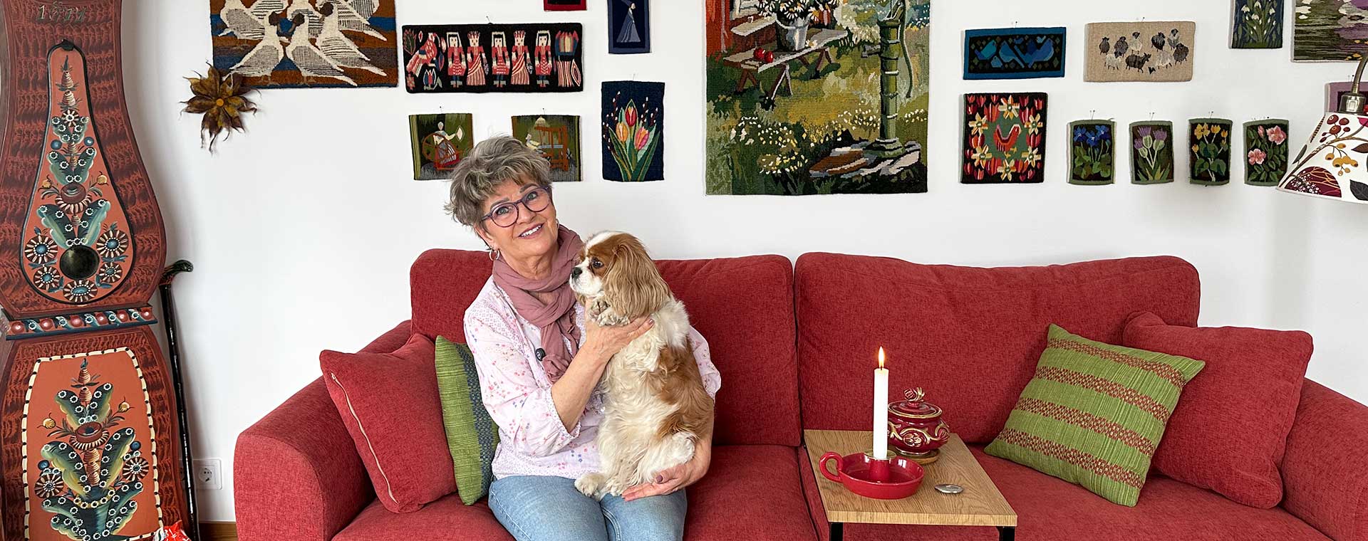 Foto på kvinna som sitter i soffan med sin hund