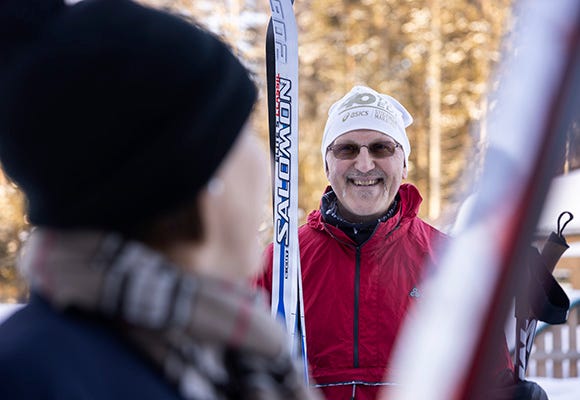 Man med skidor i händerna