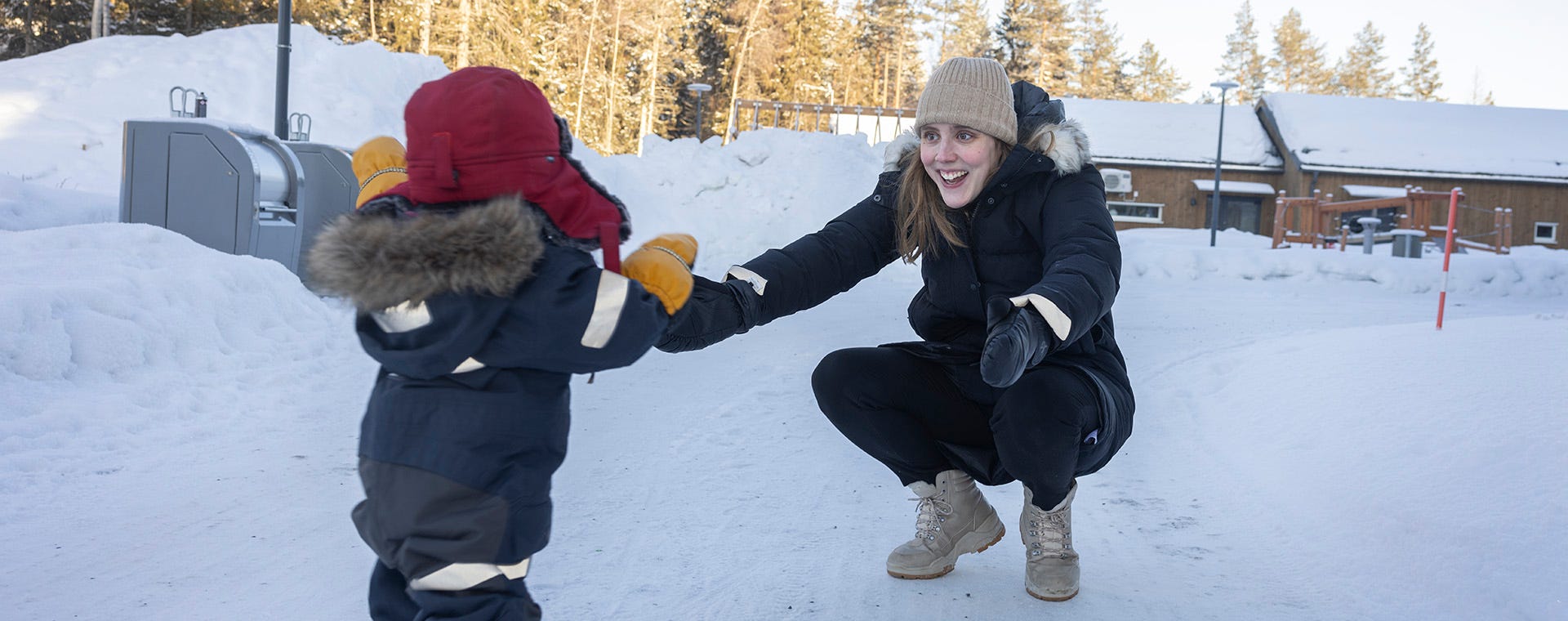 Mamma och son leker i snön
