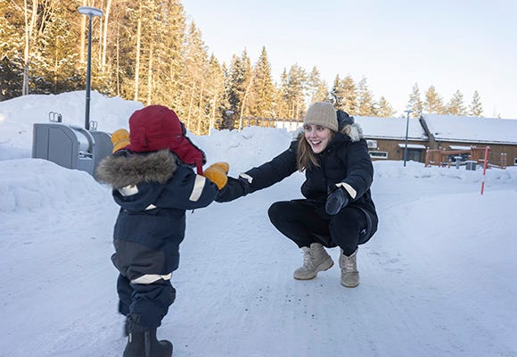 Mamma och son leker i snön