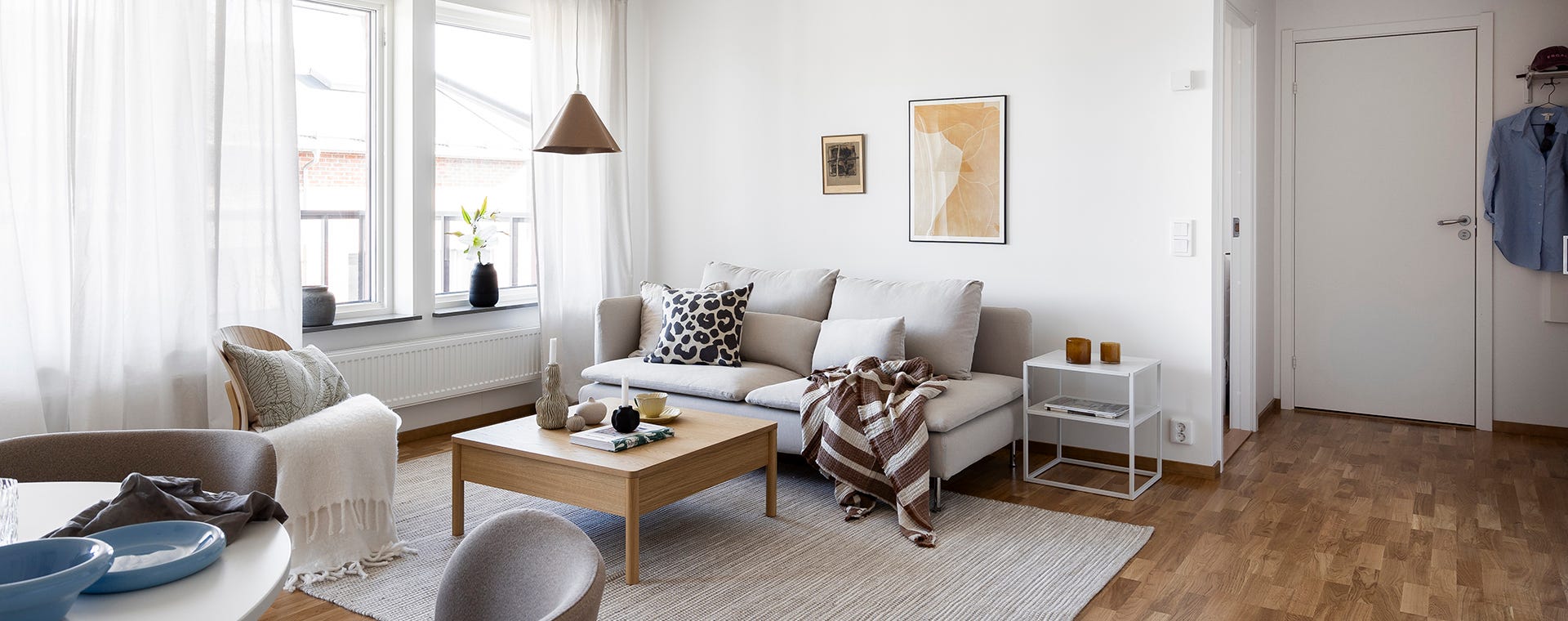Foto på vardagsrum med soffa och soffbord i ljusa färger