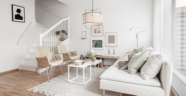 Foto på vardagsrum med en trappa till övervåningen bredvid i radhus i Kareby Äng 