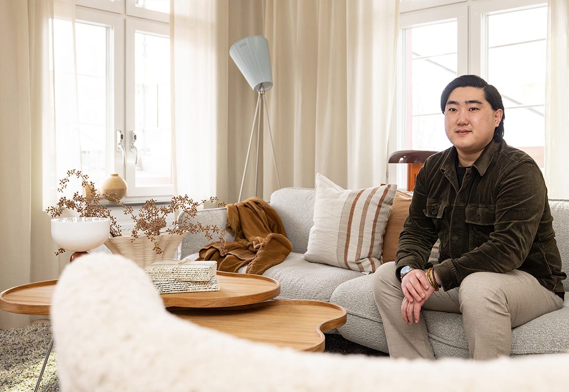 Foto på en man som sitter i en vit soffa