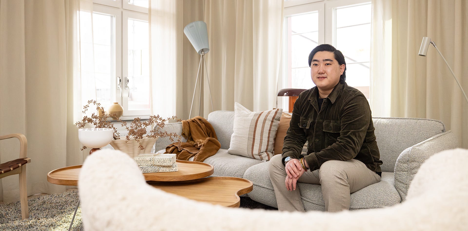 Foto på en man som sitter i en vit soffa