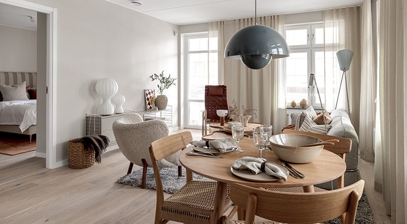 Foto på ett vardagsrum med ett matbord i förgrunden