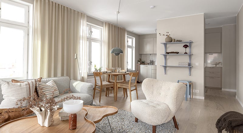 Foto taget i ett vardagsrum som blickar mot kök och matbord