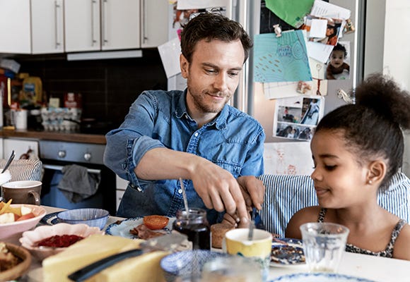 Foto på pappa och dotter som sitter och äter frukost 