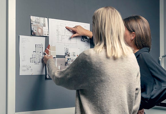 Två kvinnor kollar på planritningar