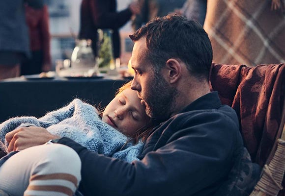 Foto på barn som sover i pappas knä 