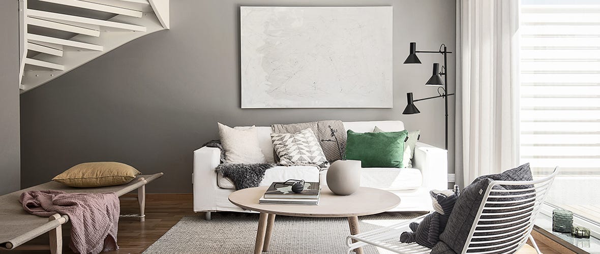 Bild på nyproducerat vardagsrum med soffa, sittplatser, och tavla