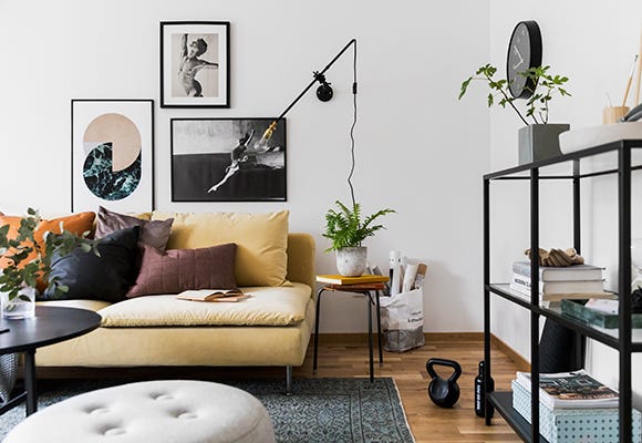 Foto på vardagsrum med soffa och tavlor
