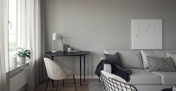 Foto på vardagsrum med en soffa och ett skrivbord 