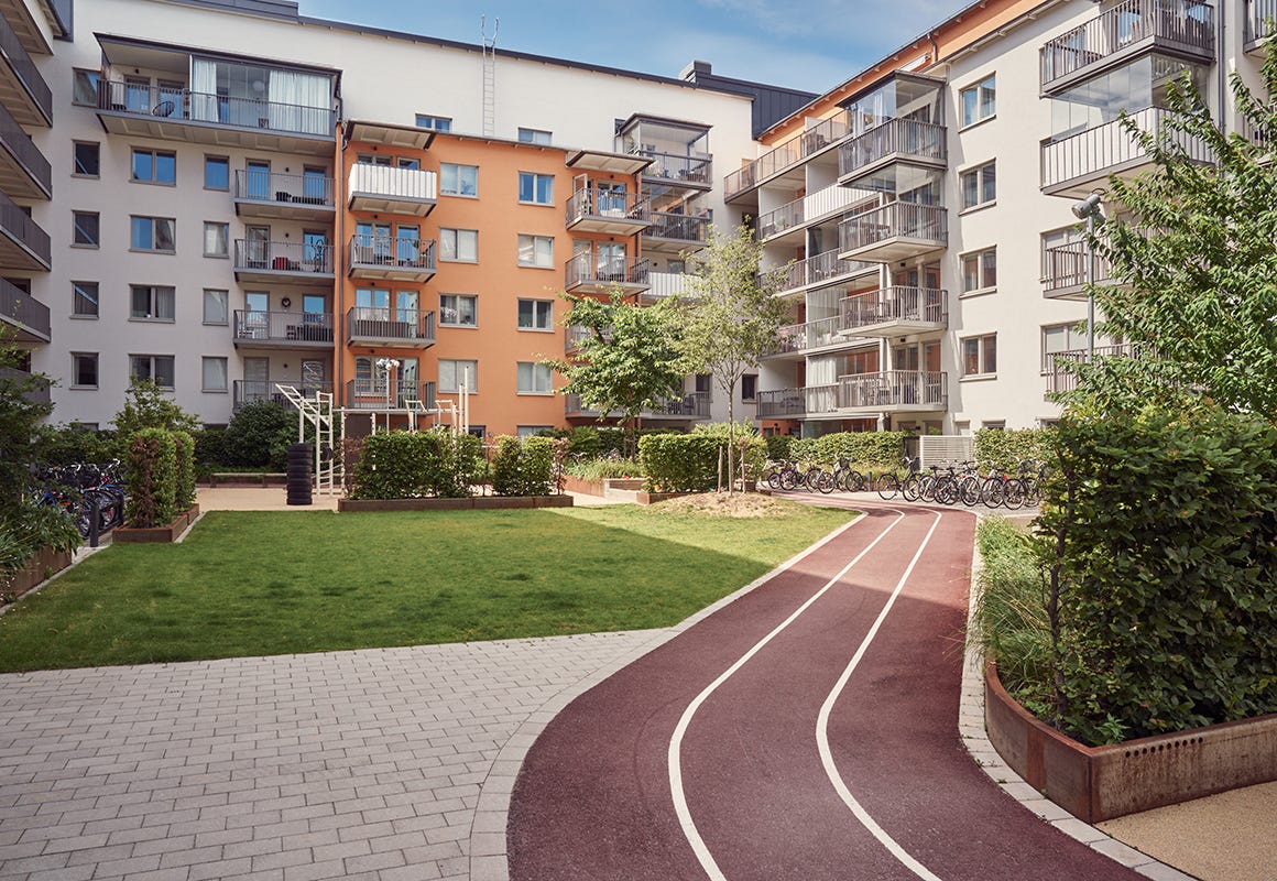 Foto på innergården med löparbana och cykelställ i grannskapet Kapellgärdet Arena