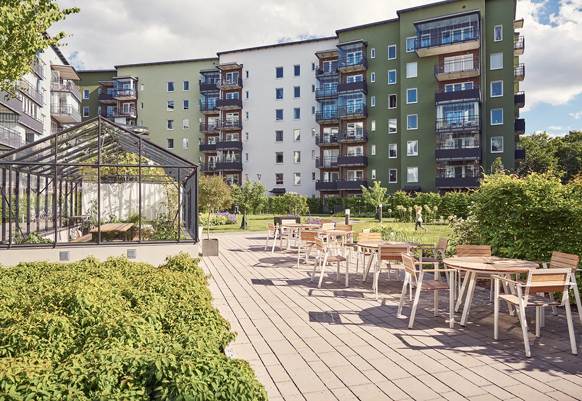 Foto på innergården med bord, sittplatser och växthus i grannskapet Kungsträdgårdarna