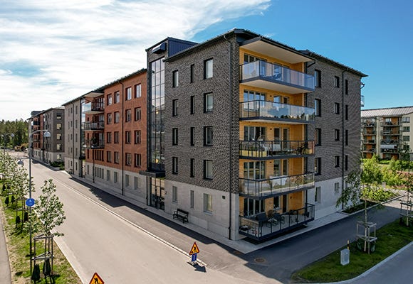 Foto på modern lägenhetsbyggnad och gatan bredvid