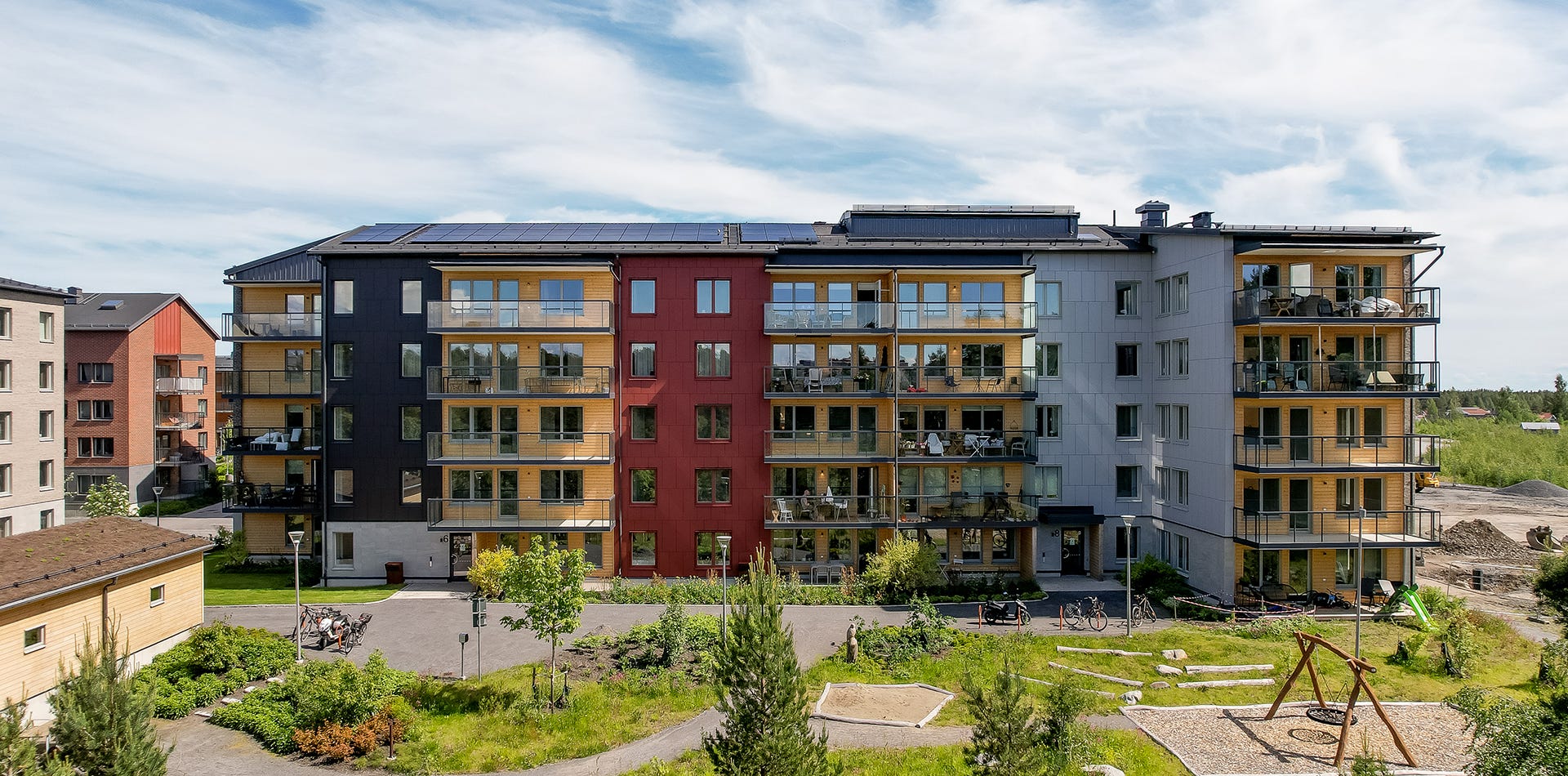 Foto på färgglad lägenhetsbyggnad med balkonger