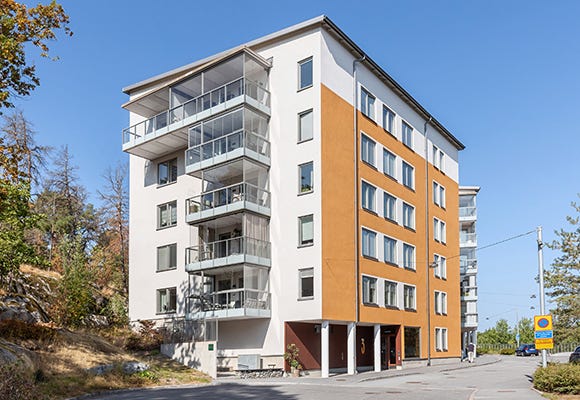 Foto på en vit och orange lägenhetsbyggnad