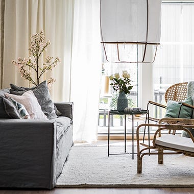 Foto på vardagsrum med soffa och stora fönster