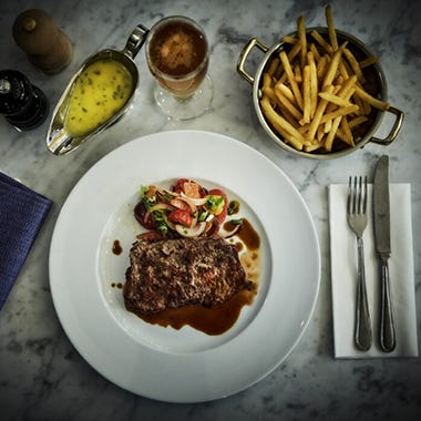 Närbild på kötträtt med pommes och bearnaise