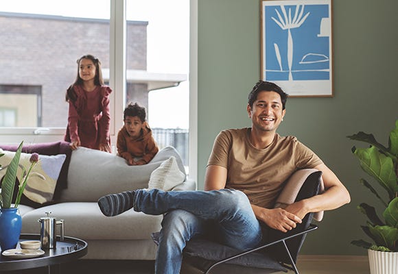 OBOS Medlem Foto på familj som sitter i sitt vardagsrum
