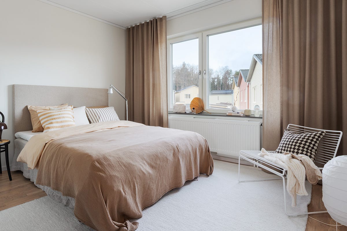 Foto på sovrum med säng och stora fönster