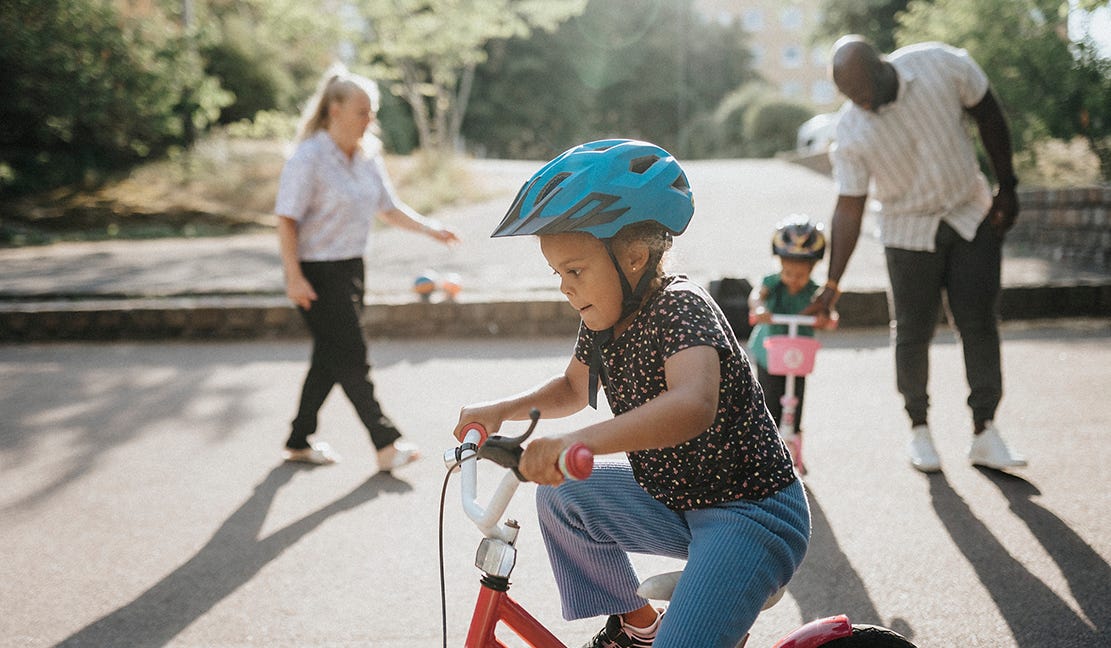 Foto på barn som är ute och cyklar med familjen