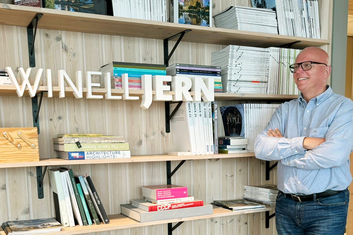 Foto på arkitekt Bengt Winell vid en bokhylla