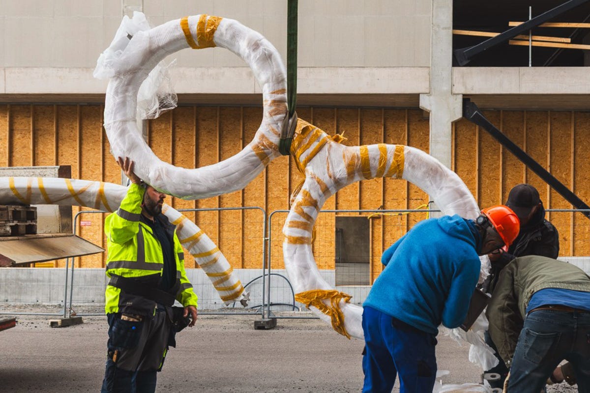Bild till highlight på projetksidan för Explora med personer som reser en staty vid namn Upptäckaren