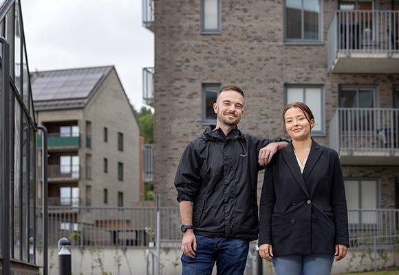 Foto på man och kvinna som står utanför ett hus